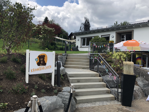 Ein Treppenaufgang, mit einem Schild 'Krombärchen' führt zum Gebäude des Krombacher Kindergartens.