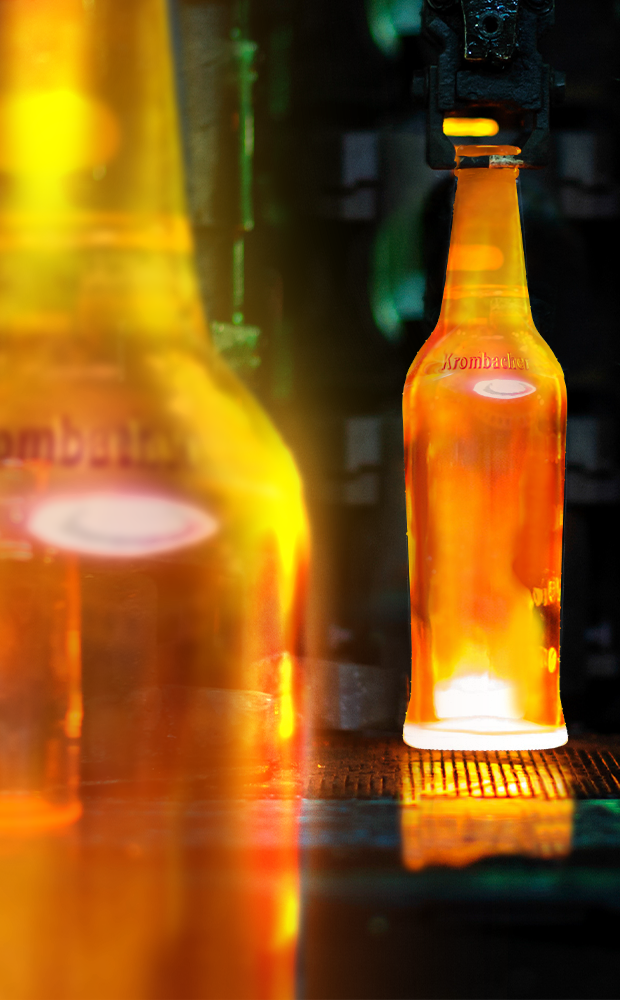 Unbefüllte Krombacher Pils 3,0l Glasflasche mit dem Schriftzug 'Krombacher' wird in einer Abfüllanlage erhitzt