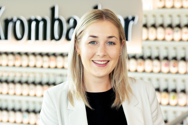 Portrait von Milena Jannek, HR Business Partnerin und Leitung Ausbildung / Duales Studium. Sie hat schulterlange hellblonde Haare, lächelt und trägt ein schwarzes Shirt mit weißem Blazer.