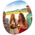 Gruppe von zwei Frauen und zwei Männern mit Krombacher Produkt in der Hand die miteinander lachen.